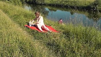 play MILF sexy Frina on river bank undressed and sunbathes naked. Random man fisherman watching for her, and in the end decided to join naked woman. Wild beach. Nudist beach. Public nudity. Public exposure. Naked in public